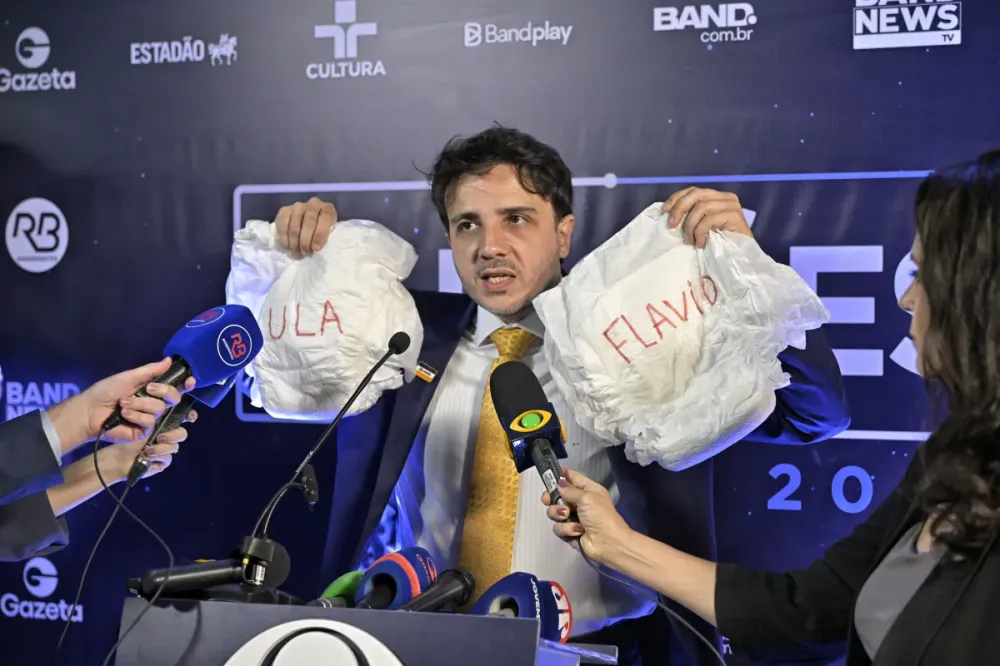Renan exibe fralda com nomes de Lula e Flávio e critica ausências em debate